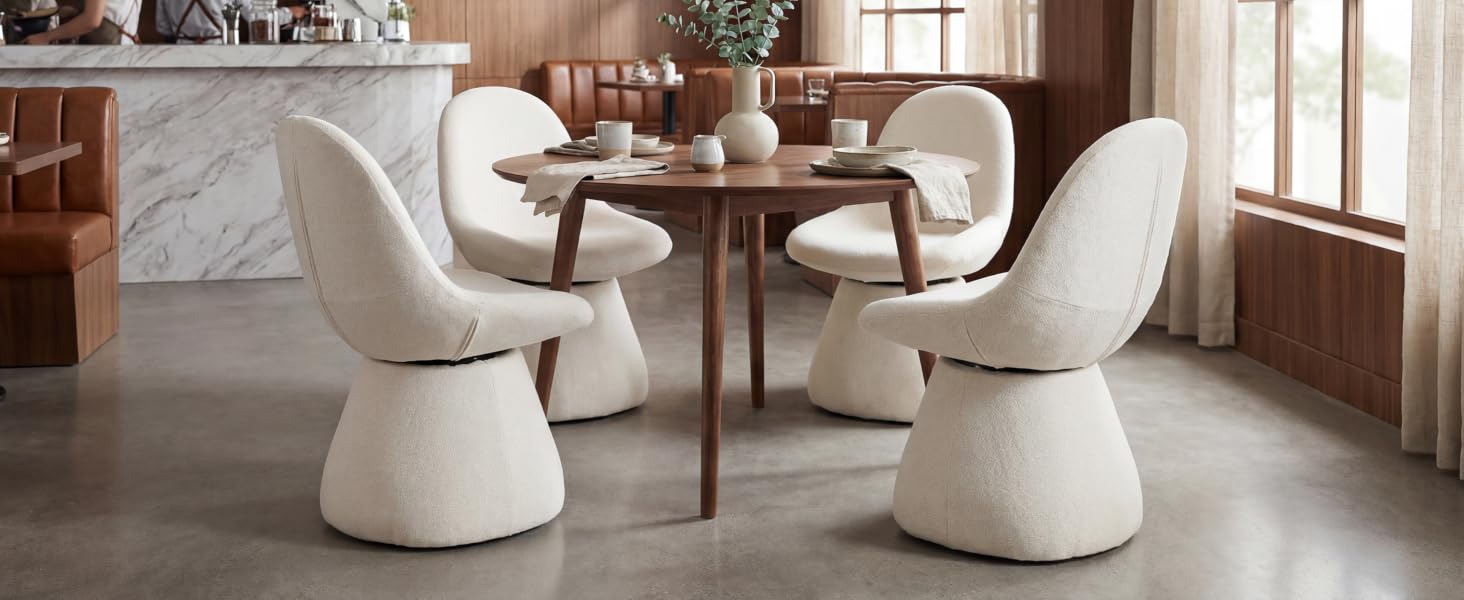 Modern dining area featuring white curved chairs and round tables in a minimalist setting with natural light. Clean contemporary aesthetic with curved furniture forms.
