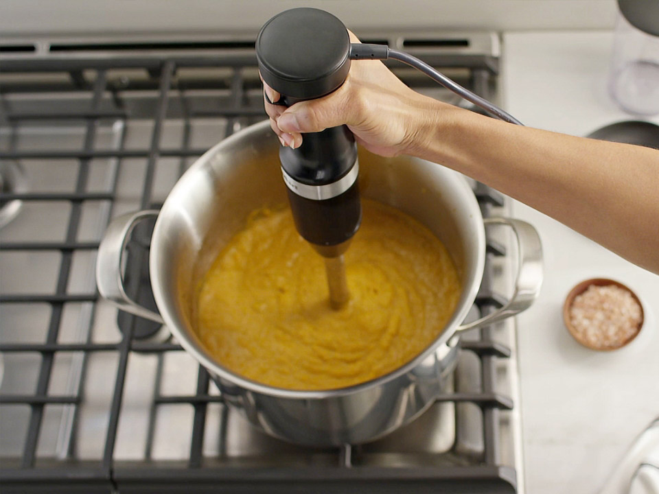 Hand-blenders-with-accessories-5KHBV83-matte-black-woman-mixing-soup