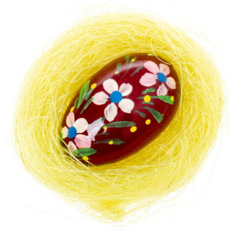 Gran huevo de Pascua de madera color burdeos en un nido amarillo