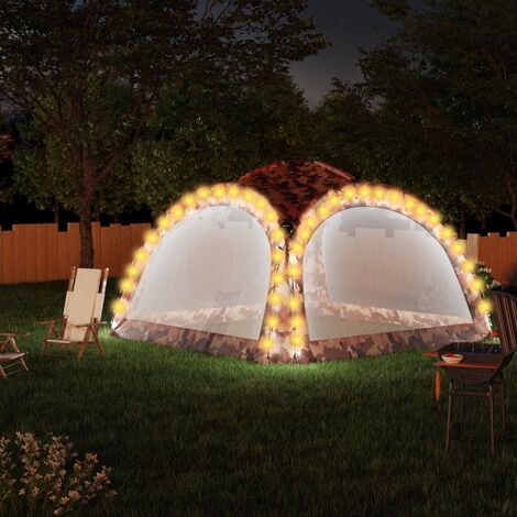 Una tienda de campaña con luces de camping instalada de noche.