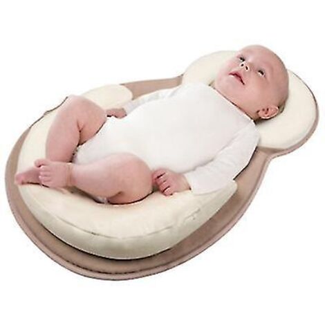 Coussin de positionnement beige pour bébé, aidant à corriger la forme de la tête et à prévenir les débordements de lait.