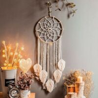 2Une tapisserie attrape-rêves tissée à la main avec des pompons en coton, dans un style bohème.