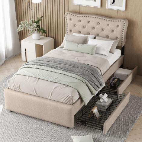 Lit plat de 90×200 cm. Le lit est recouvert de coussinets. Les tiroirs du lit sont dotés de crochets décoratifs. Il y a également des tiroirs doubles. La couleur du lit est beige foncé. (1/5)