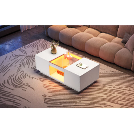 Table de salon blanche, dimensions : 100x50x35,5 cm. La table est revêtue de verre. Elle est équipée d’un éclairage LED. Il y a 2 tiroirs et 1 compartiment ouvert. (1/5)