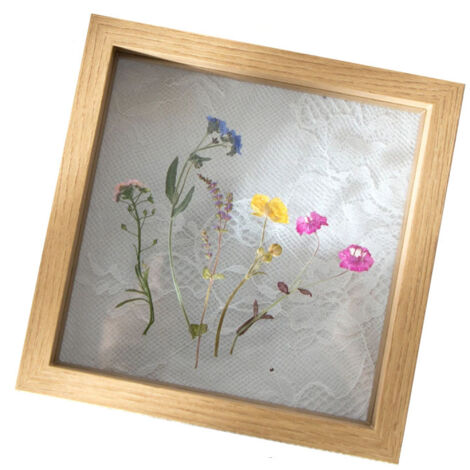 Marco de madera con frontal de cristal, decorado con flores y hojas secas, ideal para una foto de boda o para decorar una oficina.