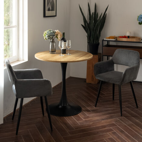 MEUBLES COSY Un ensemble de salle à manger trois pièces, comprenant une table ronde avec des pieds en métal et deux chaises de salle à manger en velours côtelé gris.