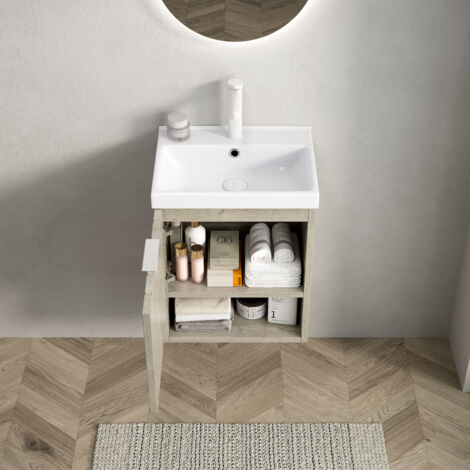 Mueble de baño suspendido con lavabo de cerámica blanca puertas dobles y estantes abiertos textura de roble color crema