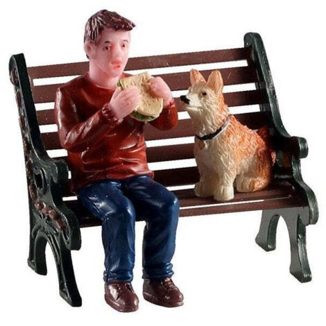 Pausa pranzo con il cane seduti sulla panchina personaggio in poliresina per villaggio di Natale