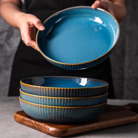 Assiette creuse en céramique bleue avec lignes dorées