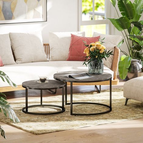 Set di 2 tavolini da caffè impilabili, dal design industriale, con piano effetto cemento e gambe in metallo grigio.
