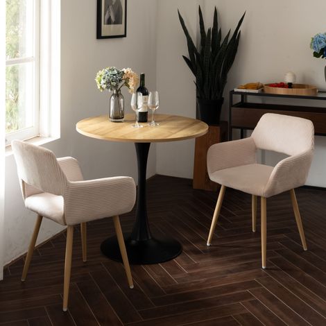 MEUBLES COSY Un ensemble de salle à manger trois pièces, comprenant une table ronde avec des pieds en métal et deux chaises de salle à manger en velours côtelé beige. (1/5)
