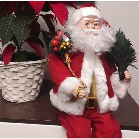 Babbo Natale seduto con animazione e fibra ottica colorata.