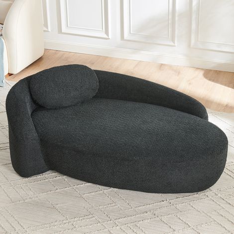 Sofá negro en Lammfell-Optik con diseño redondeado y cojín reposacabezas (1/5)