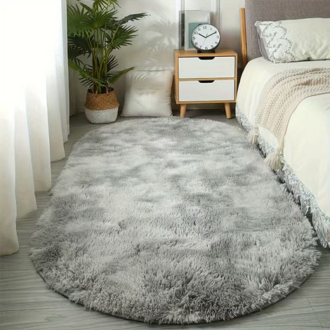 Dieser hellgraue, ovale Teppich ist rutschfest und fleckenabweisend und eignet sich ideal für Ankleidezimmer, Schlafzimmer oder neben dem Bett. Seine Maße sind 100 x 200 cm.