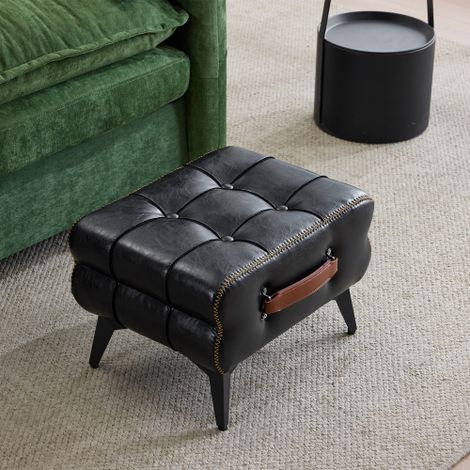Repose-pieds portable en cuir noir aux pieds métalliques. Repose-pieds multifonctionnel. Tabouret universel pour se chausser, idéal pour le salon et la chambre. De style épuré, il s'intègre harmonieus