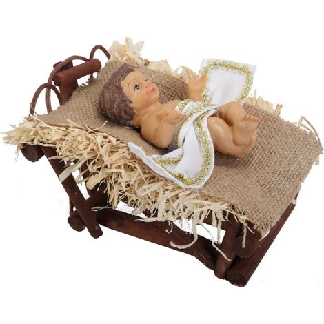 Una statuetta di Gesù Bambino adagiato in una mangiatoia sul fieno