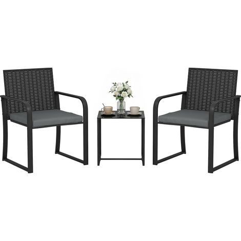 Ensemble de mobilier de jardin en rotin synthétique comprenant 2 chaises avec coussins et une table avec plateau en verre gris.