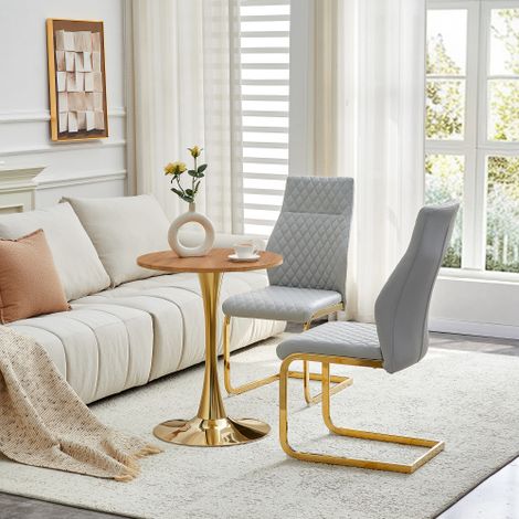 Ensemble table et chaises. Table ronde de 60 cm en MDF imitation bois, pied de support doré, assortie à 2 chaises de salle à manger gris clair à motif losanges et structure en métal doré. (1/5)