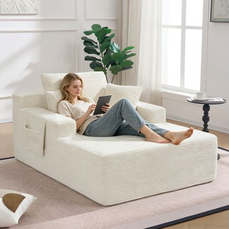 Un comodo divano in velluto a coste, che non richiede montaggio, con morbidi cuscini per schienale e seduta e tasche laterali per riporre telecomandi e cellulari: un design semplice ed elegante. (1/5)