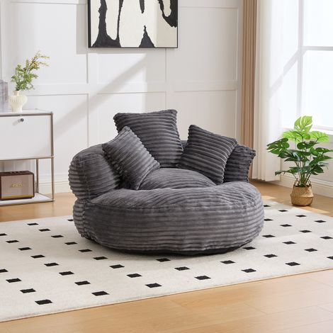 Sillón puf de corduroy gris oscuro con respaldo alto, reposabrazos curvos y asiento amplio (1/5)