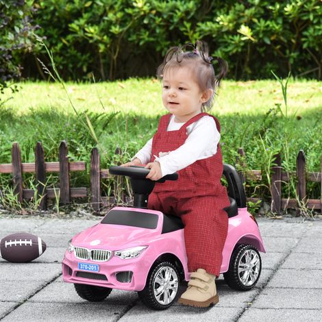 Voiture électrique pour enfant avec volant. Lumières et musique intégrées. En polypropylène et métal. 63,5 x 28 x 36 cm. Rose.
