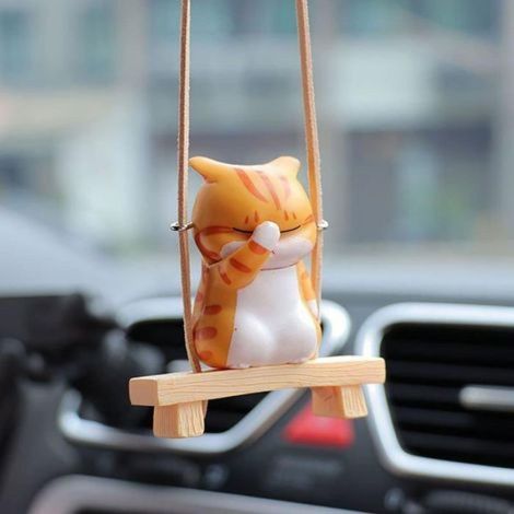 Un chat se cache le visage sur une balançoire un pendentif décoratif en plastique pour voiture. (1/5)