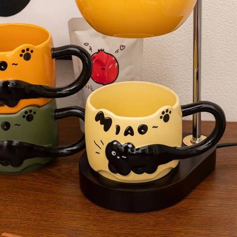 1 Stück. Farbe: Gelb. Material: Keramik. Schwarze Katzentasse mit geprägtem Muster und großem Henkel. Kaffeetasse.