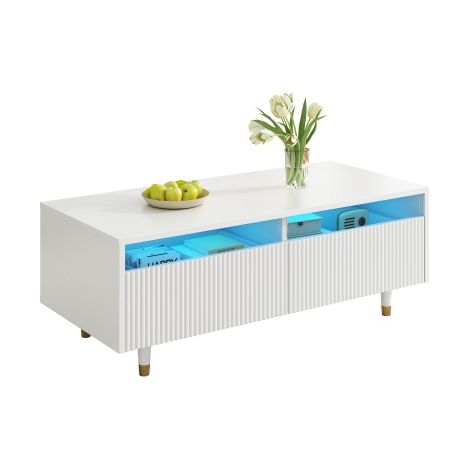 Cette table basse moderne à LED est dotée d'un plateau à tiroirs ondulé, de pieds dorés et blancs, de deux tiroirs et de bandes lumineuses LED à couleurs changeantes. Un meuble TV assorti est égalemen