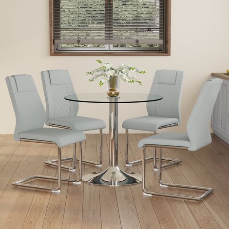 Ensemble table à manger moderne et minimaliste en verre de sécurité, diamètre 85 cm, avec 4 chaises de salle à manger à pieds métalliques argentés et assises en PU gris clair.