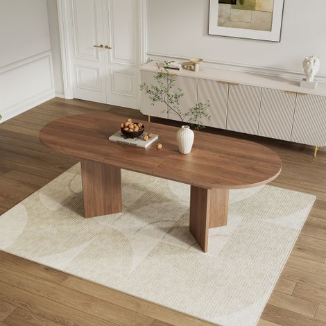 Table de salle à manger extensible (120/160 x 80 cm) pouvant accueillir 4 à 6 personnes elle présente des coins arrondis, un plateau épais et un style minimaliste avec une finition noyer. (1/5)