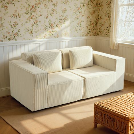 Canapé modulable trois places avec assise profonde. Larges accoudoirs et deux coussins en velours côtelé. Beige.