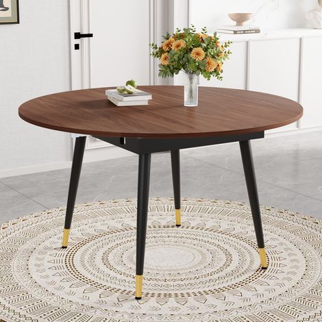 Mesa de comedor redonda extensible a ovalada, de MDF, patas de metal, acabado en nogal con detalles dorados. (1/5)