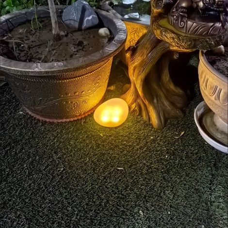 Une lampe de jardin solaire, ornée de galets artificiels, adaptée aux pelouses extérieures. (1/5)