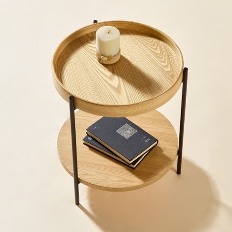 Table basse ronde à deux niveaux, fabriquée en bois massif et métal. Disponible en trois finitions : Frêne naturel, Noyer et Noir. Conçue pour compléter parfaitement la table d'appoint assortie de la  (1/4)