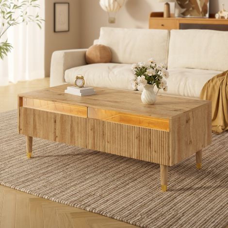 Cette table basse moderne à LED est dotée d'un plateau à tiroirs ondulé, de pieds dorés et blancs, de deux tiroirs et de bandes lumineuses LED à couleurs changeantes. Un meuble TV assorti est égalemen