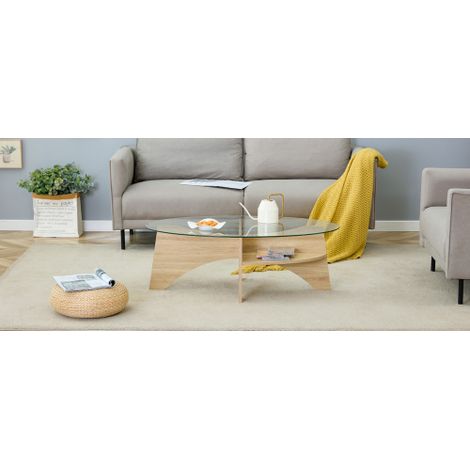 Table basse ovale en verre de sécurité — Design multifonctionnel. Le piètement de la table se compose de compartiments disposés en diagonale, dans une palette de couleurs claires, et intègre des étagè