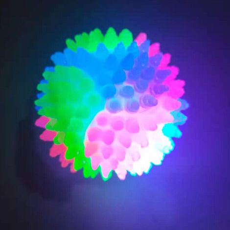 Une balle pour chien élastique tricolore clignotante de 5,5 cm de diamètre, avec un effet phosphorescent. (1/3)