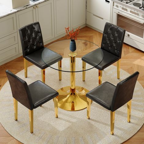 Ensemble table et chaises: table à manger ronde moderne minimaliste de 85 cm de diamètre en verre avec support métallique doré, assortie à 4 chaises de salle à manger modernes noires et dorées.