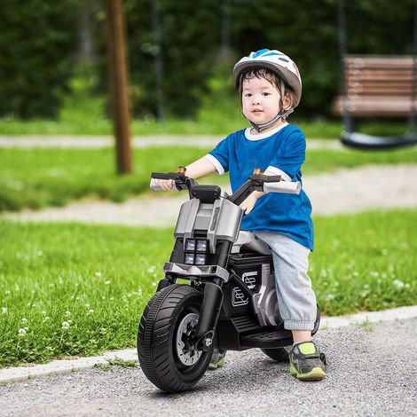 Moto eléctrica de 6 V para niños con ruedines, claxon, 4 faros y música. Patinete eléctrico para niños de 3 a 5 años en PP y metal. Velocidad: 3 km/h. Dimensiones: 86 x 44 x 58 cm. Color: blanco.