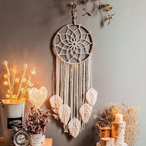2Une tapisserie attrape-rêves tissée à la main avec des pompons en coton, dans un style bohème. (1/5)