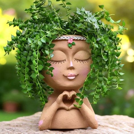 Ein Blumentopf in Form eines Gesichts mit herzförmiger Hand, ein Zimmerpflanzentopf mit Harzkopf und niedliche Sukkulententöpfe mit Abflusslöcher (1/5)
