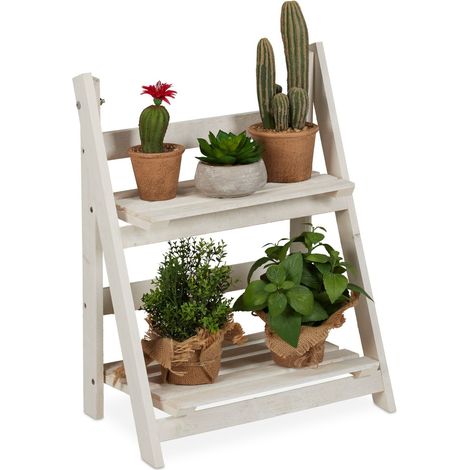 Escaleras blancas con flores de madera.