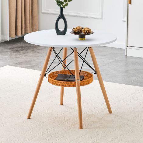 Table ronde Ø 80 cm, plateau MDF blanc, piètement bois massif, panier tressé suspendu intégré, convient pour 2 à 4 personnes.