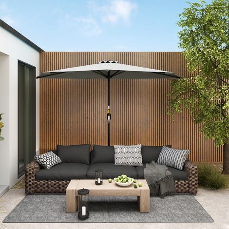 Parasol mural en forme de croissant, peu encombrant, avec ouverture à manivelle. 2,7 x 2,4 m. Gris clair.