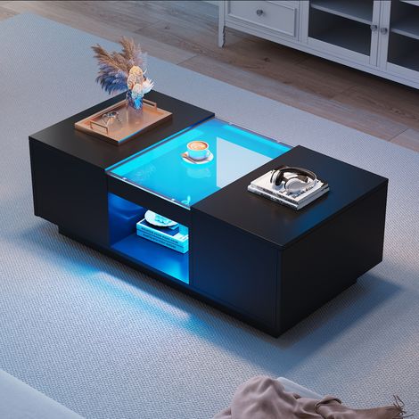 Table de salon noire, dimensions : 100x50x35,5 cm. La table est décorée avec du verre. Elle est équipée d’un éclairage LED. Il y a 2 tiroirs et 1 compartiment ouvert. (1/5)