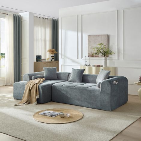 Sofá esquinero azul de tela con asiento de espuma y muelles, respaldo inclinado y bolsillo lateral para revistas, diseño envolvente para salón moderno CHICFURN (1/5)