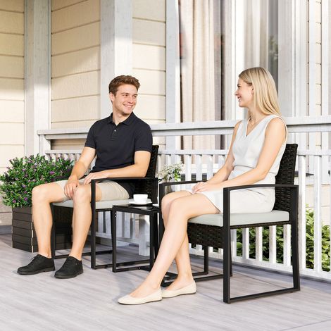 Set di mobili da giardino in rattan sintetico con 2 sedie con cuscini sfoderabili e tavolo con piano in vetro color crema.