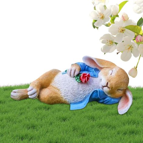 entzückendes Kaninchen liegend mit dekorativ Sammelfiguren