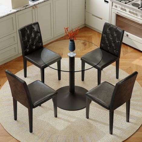 Ensemble repas au style moderne et minimaliste, comprenant une table à plateau en verre (diamètre de 85 cm) et quatre chaises chaises revêtues de similicuir (PU) avec dossiers capitonnés. (1/5)