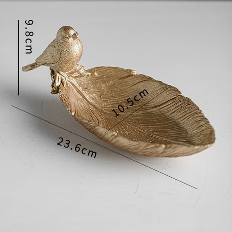 Objet décoratif moderne, minimaliste et élégant en résine, orné d'un motif d'oiseau et de feuille, pouvant également servir de porte-clés dans l'entrée.